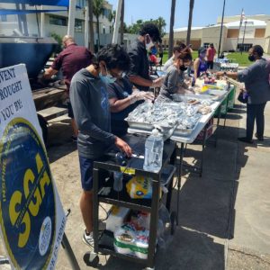 A group of Gulf Coast State College students are serving barbecue.