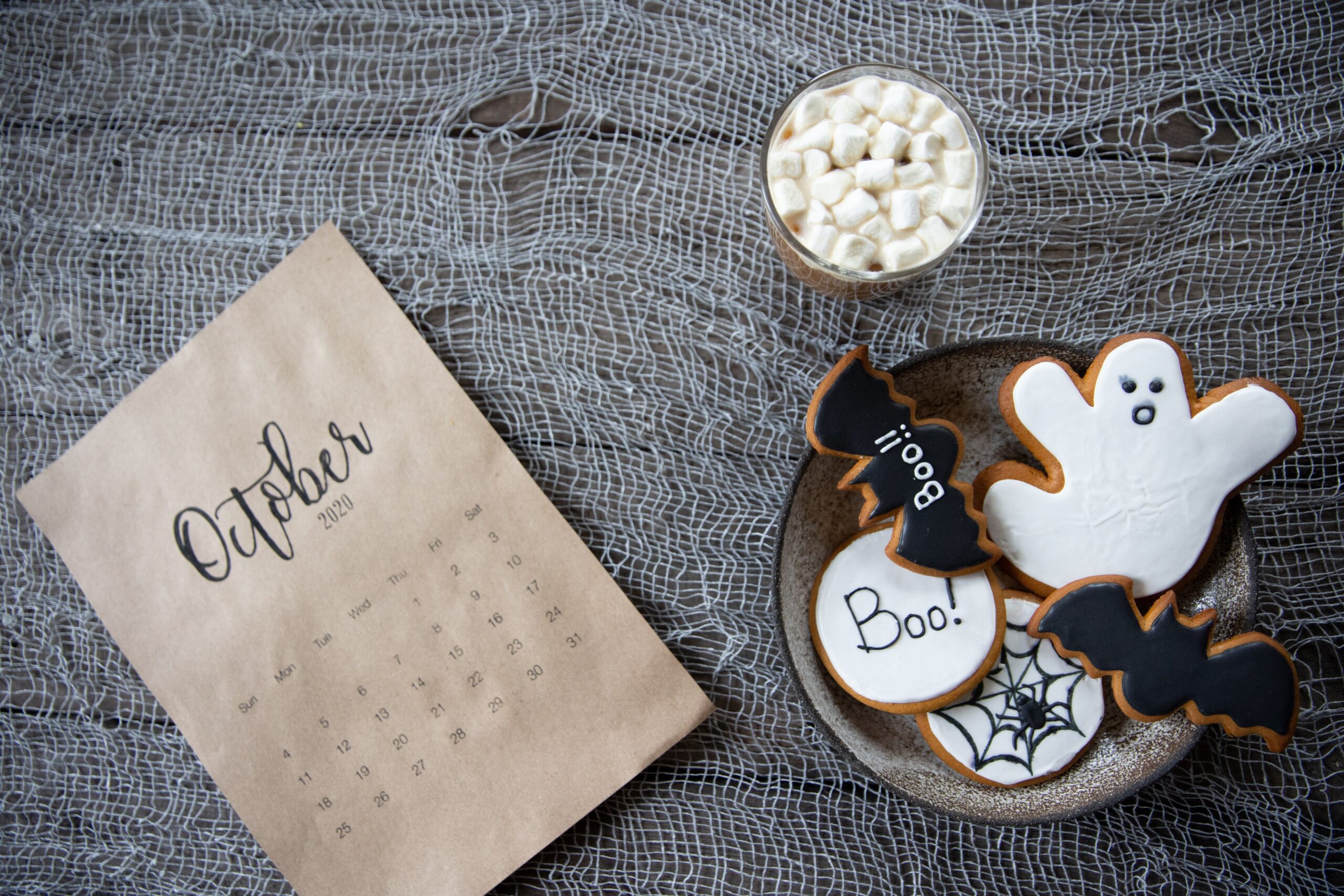 bowl to right of picture with spooky cookies and a October calendar to the left