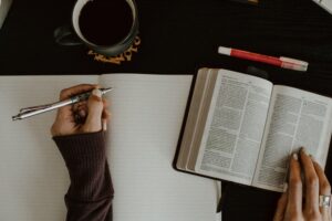 student taking notes from an open book