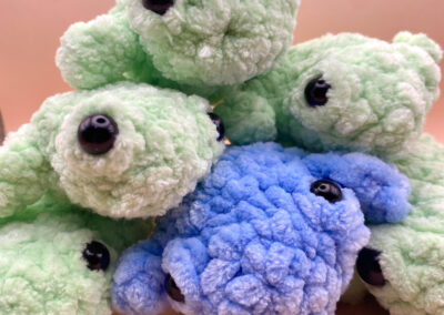 many crochet frog plushies